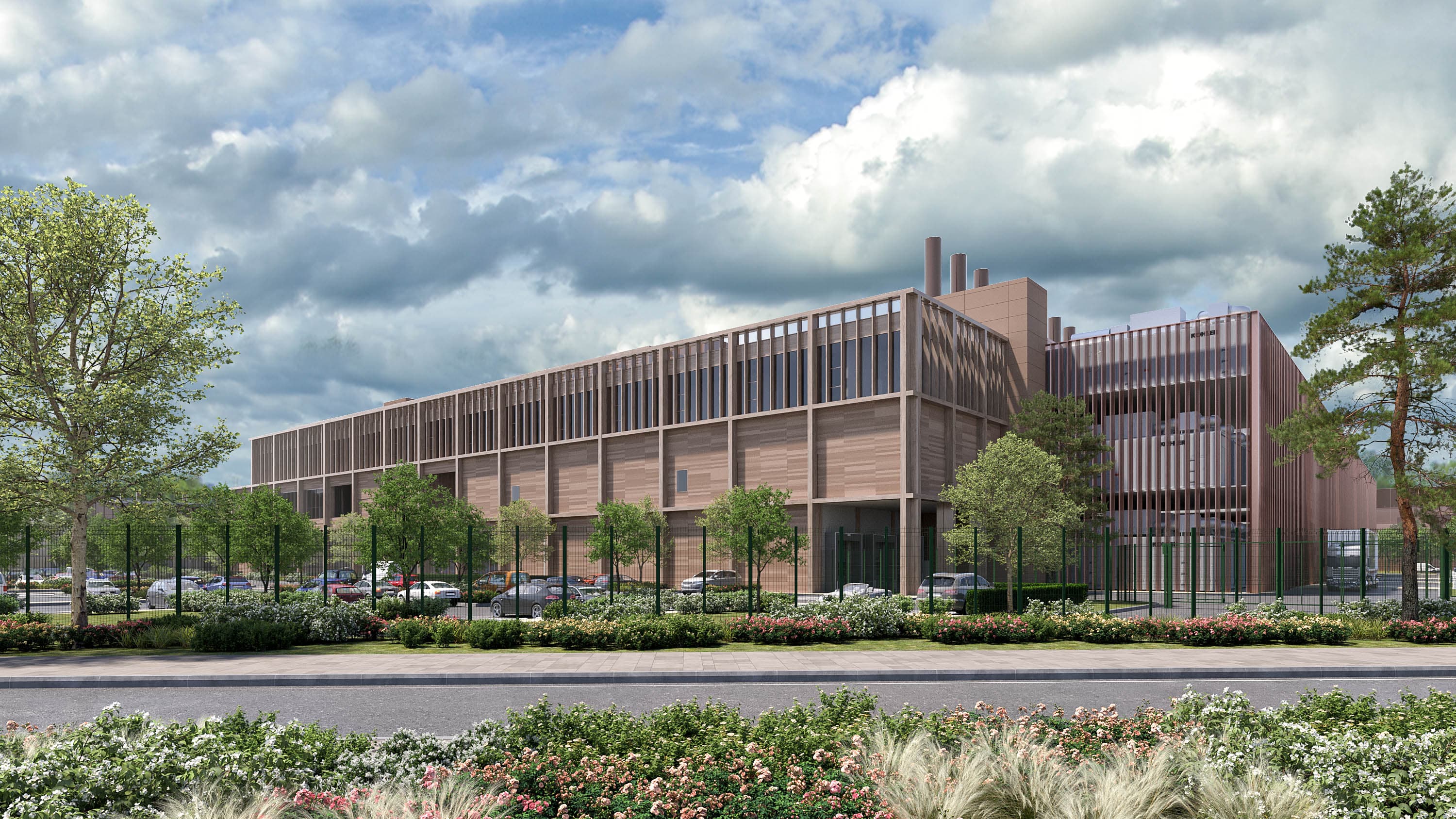 Vue depuis la rue du bâtiment data center DC01, à bardage en lattes de bois verticales et cheminées techniques, avec clôture grillagée et aménagement paysager fleuri au premier plan.